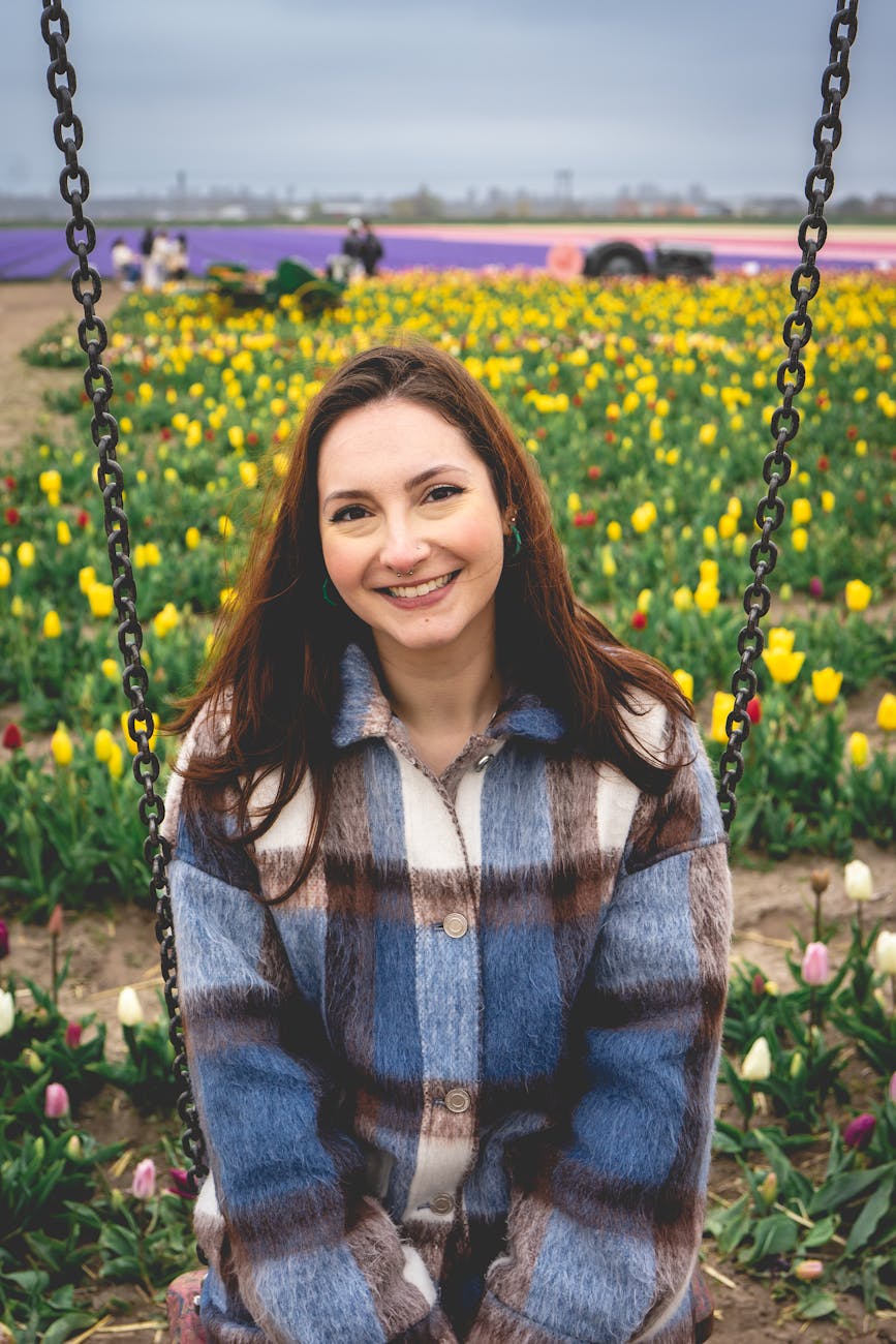 Young woman enjoying a spring day in a colorful tulip field in Hillegom, Netherlands.