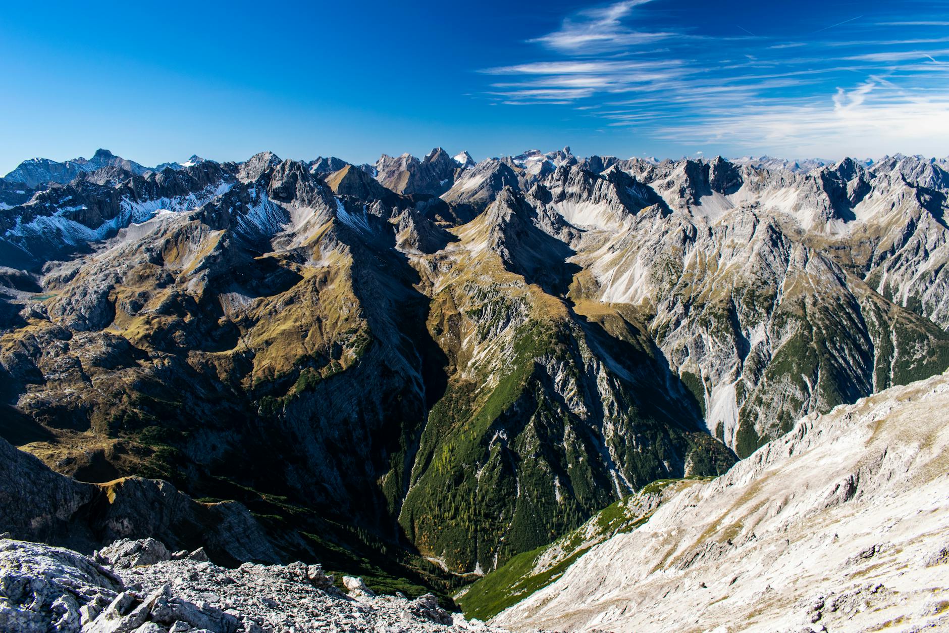 Breathtaking aerial view of rugged Alpine mountains under a clear blue sky.