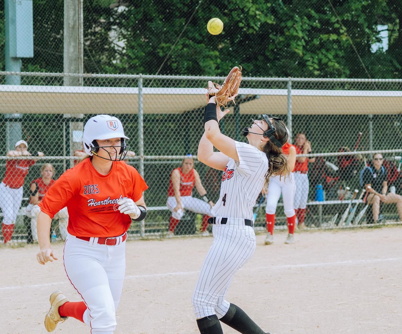 Energetic scene of teenage girls playing softball on a sunny day in Columbia, MD.