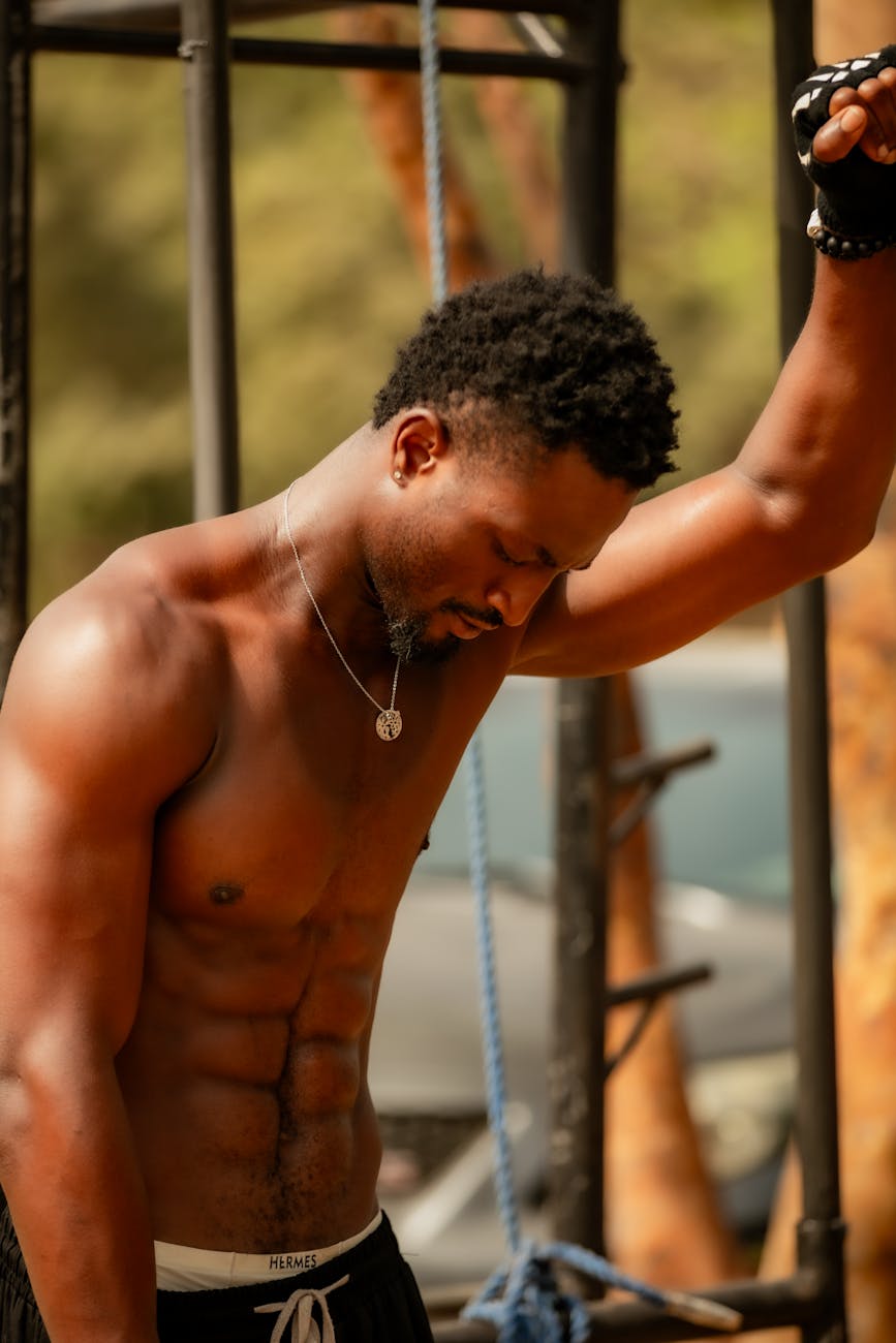 Muscular man in a gym setting showing strength and determination during a workout.