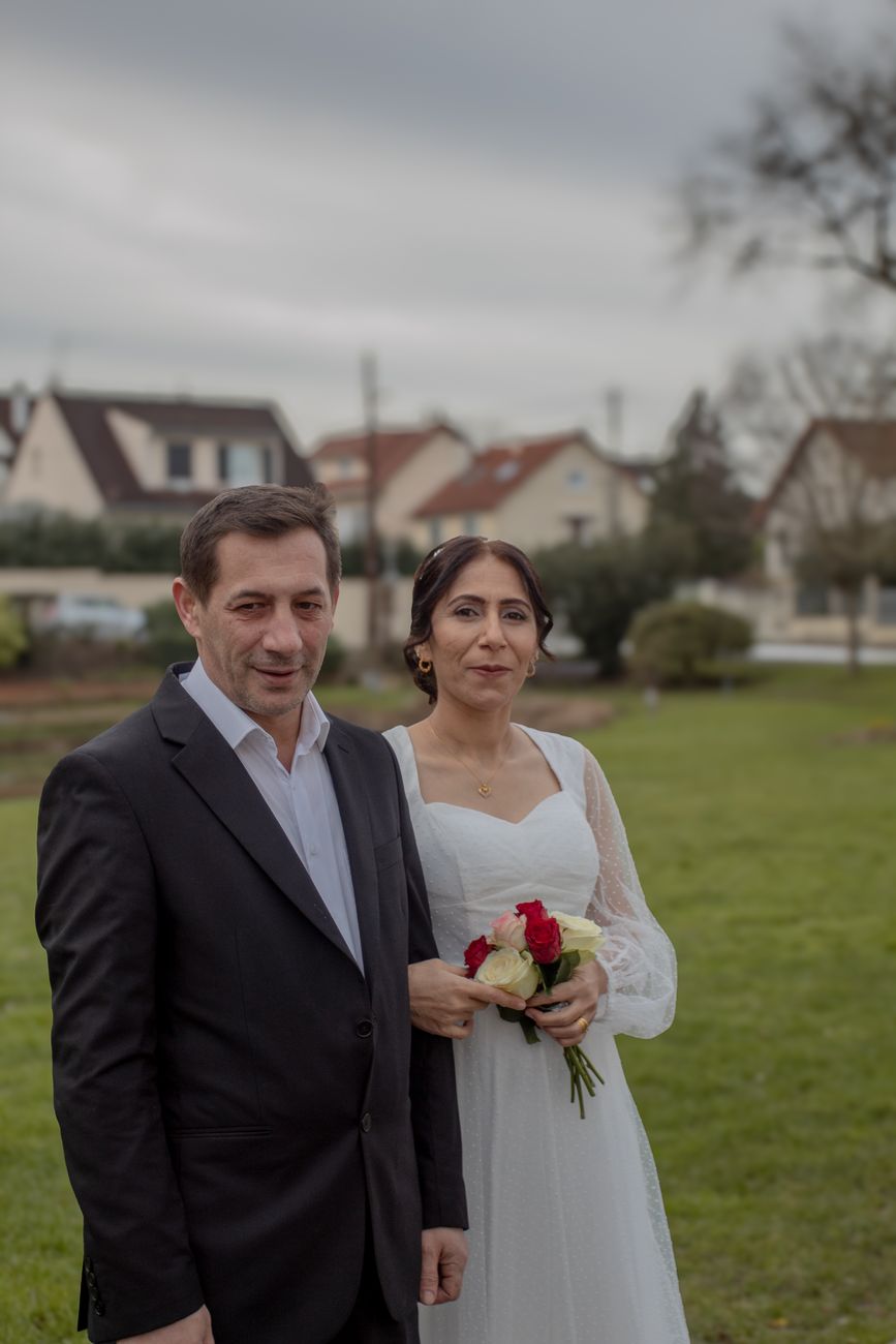 Portrait of a bride and groom in a garden setting.