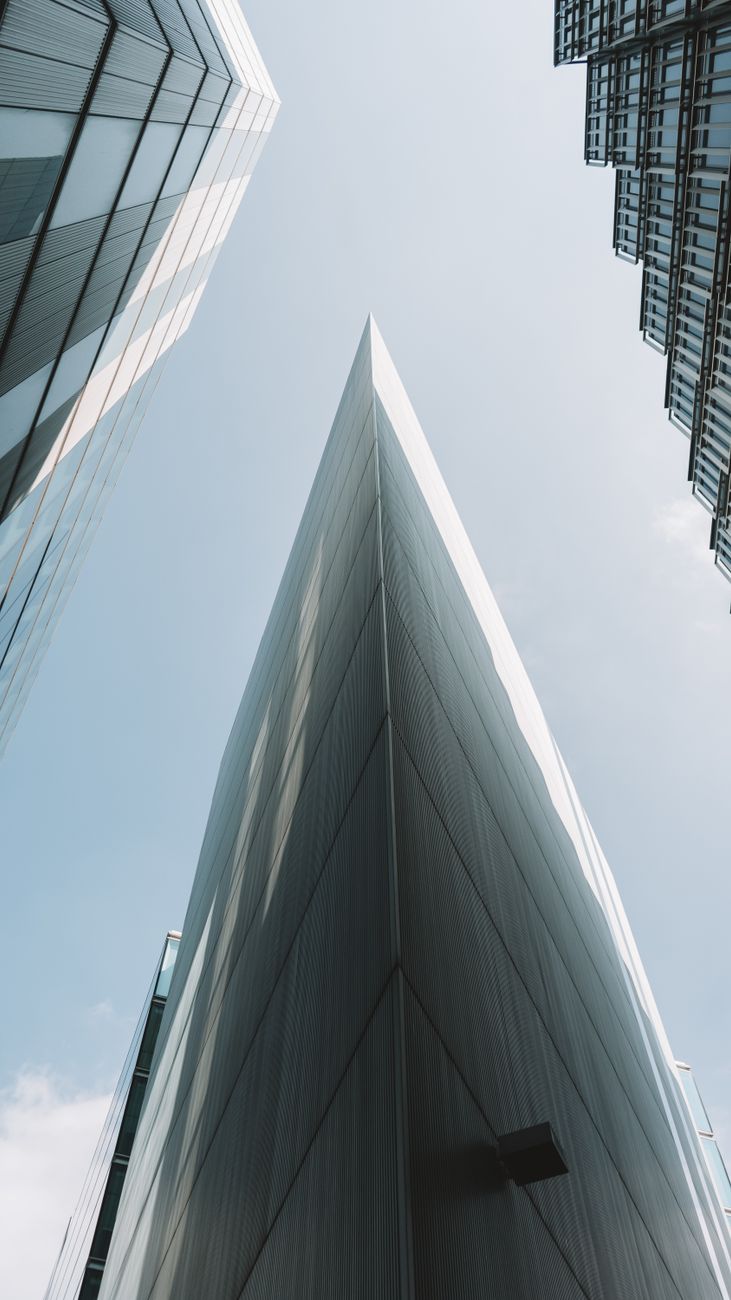 Impressive modern skyscrapers viewed from low angle against a clear sky.