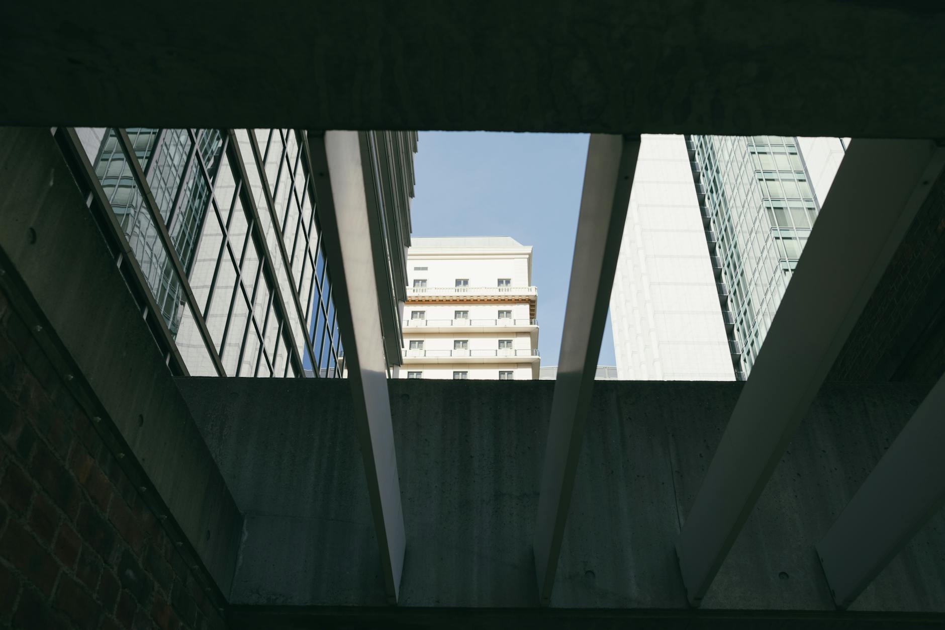 A striking view of modern buildings through concrete beams in Osaka, Japan.