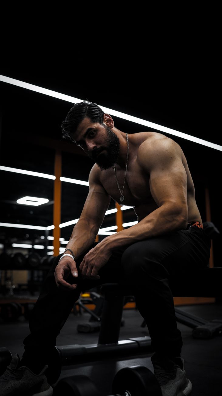 Strong man with beard and short hair sitting on a bench in a gym in Sulaymaniyah, Iraq.