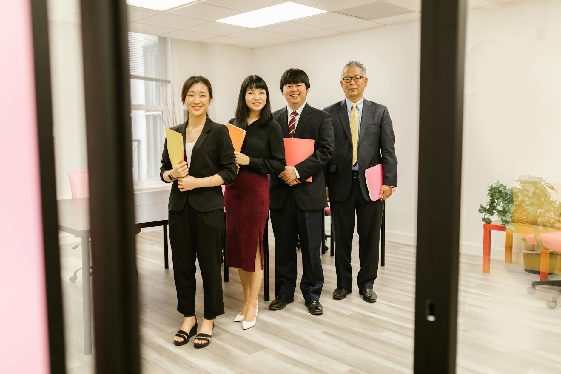 A diverse group of professionals smiling in a modern office setting, representing teamwork and collaboration.