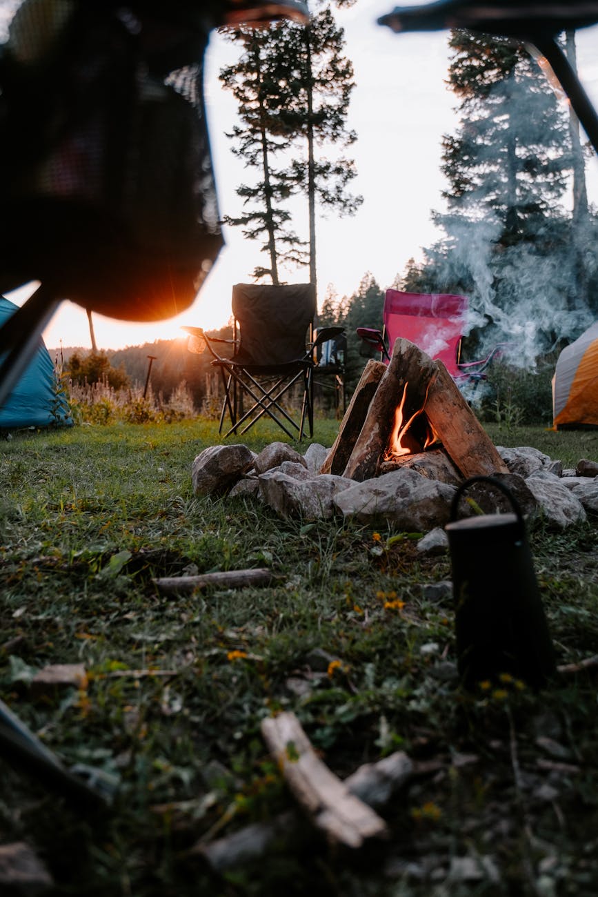 Serene camping setup with campfire and chairs at sunset in Cloudcroft, NM.