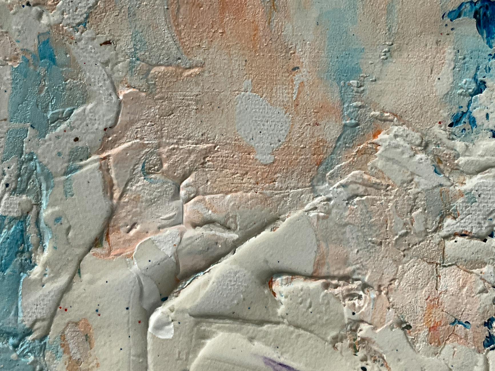 Close-up of a textured wall showing layers of colorful paint in an abstract pattern.