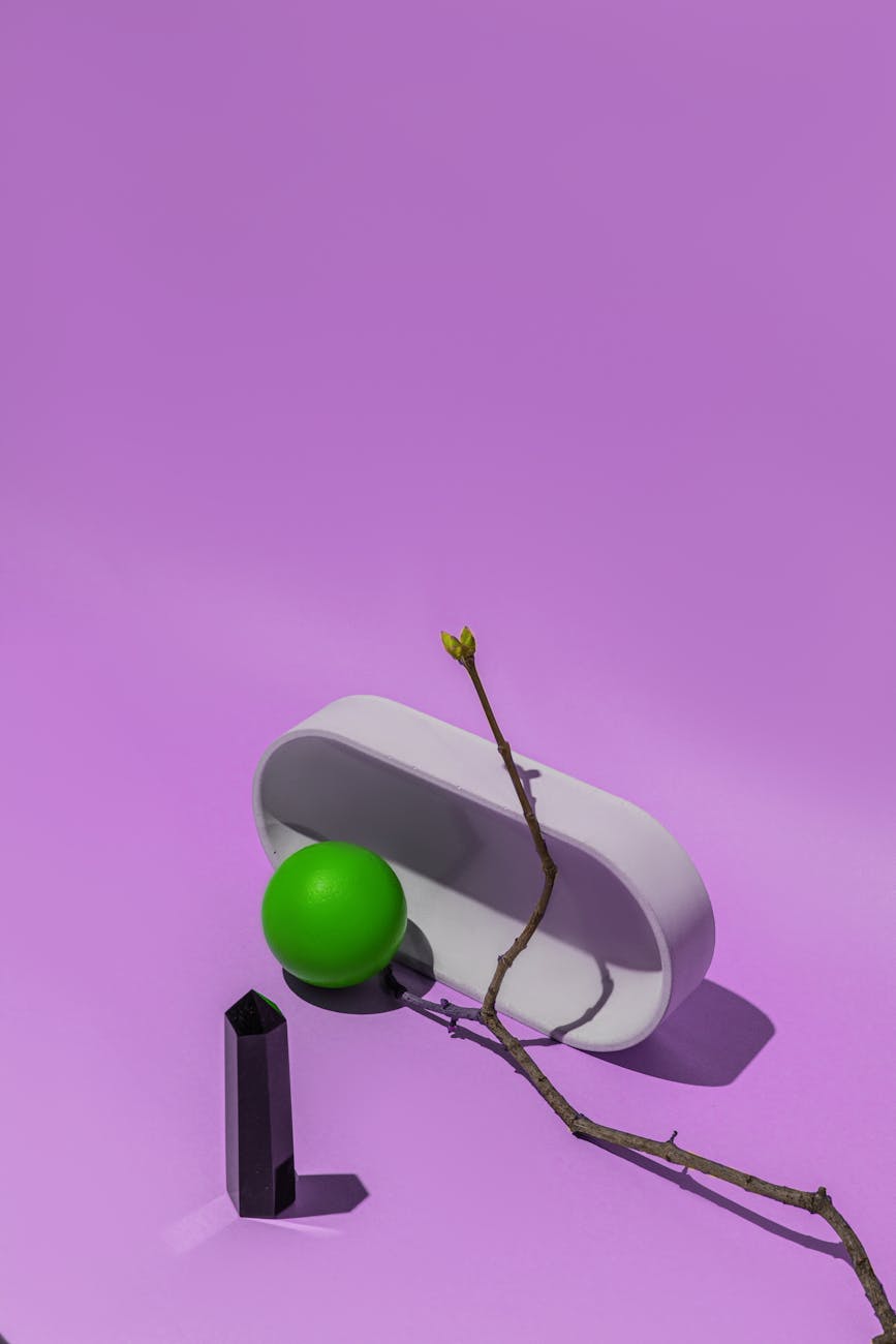 A geometric still life with a purple backdrop featuring minimalist objects.