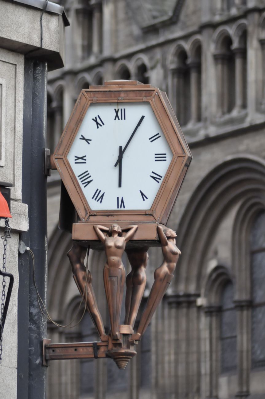 A detailed view of a classic ornate clock on a historic building in England.