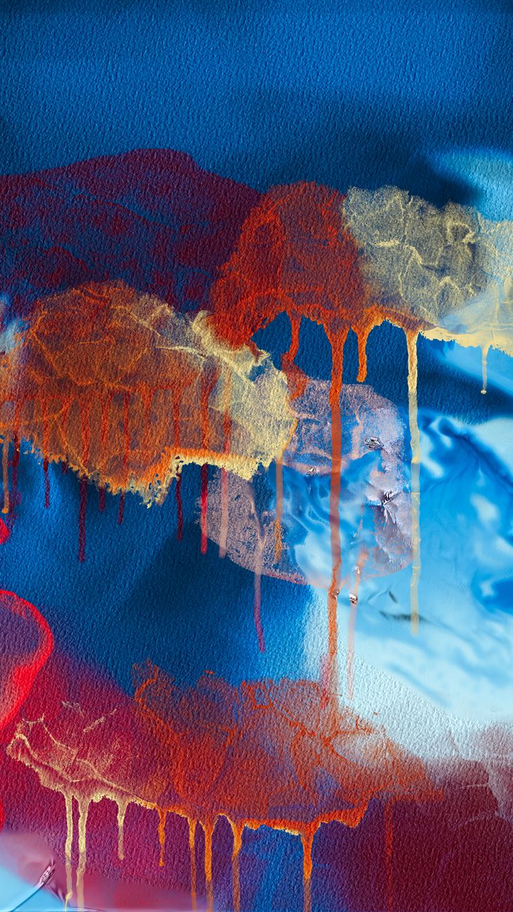 Vivid abstract painting with drips of orange, blue, and red on textured canvas.