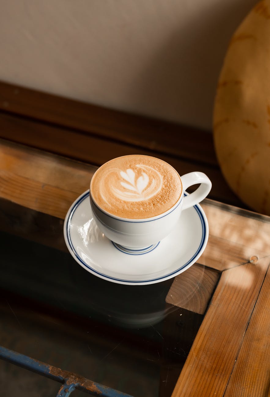 A beautifully crafted cup of coffee with latte art sits on a wooden table, offering a warm ambiance.