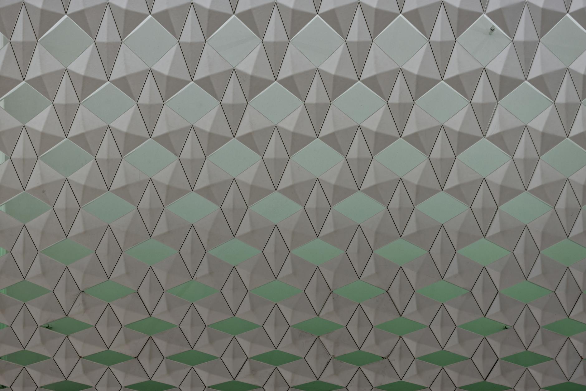 Seamless geometric pattern featuring diamond shapes in a soft color gradient.