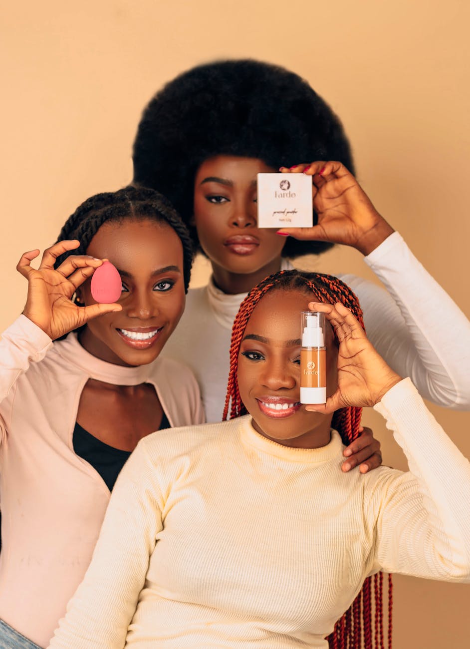 Three women showcasing beauty products and tools, celebrating diversity and confidence.