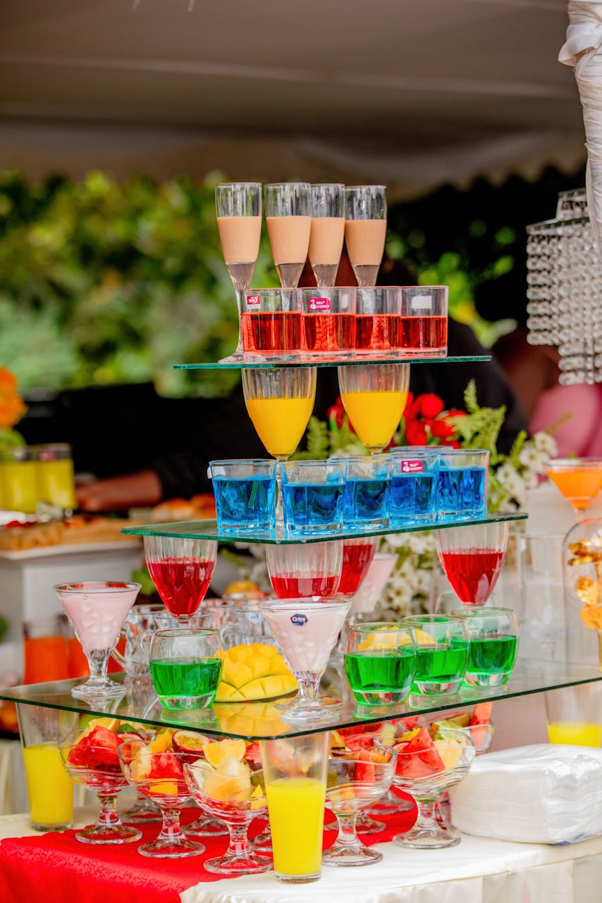 Colorful layered cocktails beautifully arranged at an outdoor event setting.