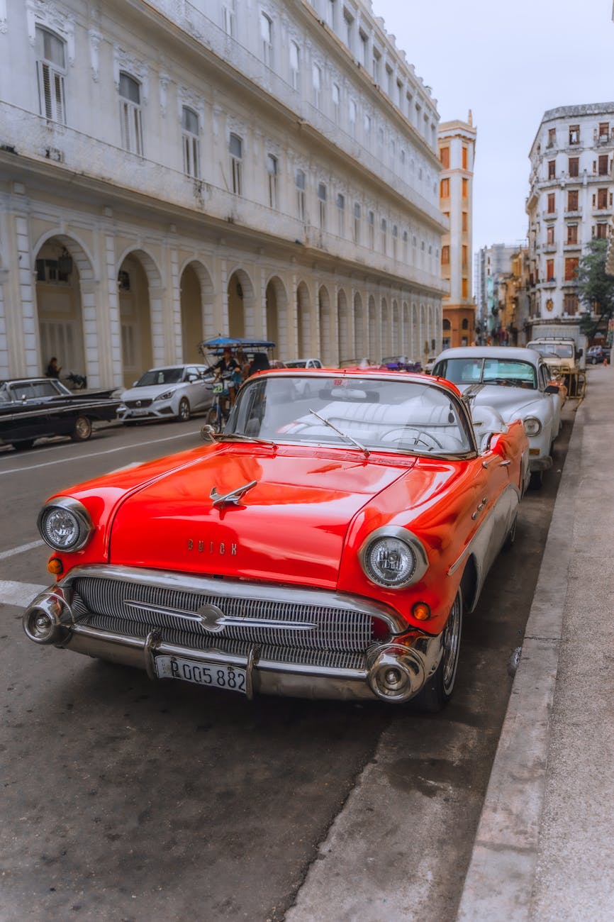 Classic 1957 red Buick parked on a Havana street, showcasing retro charm and Cuban street life.