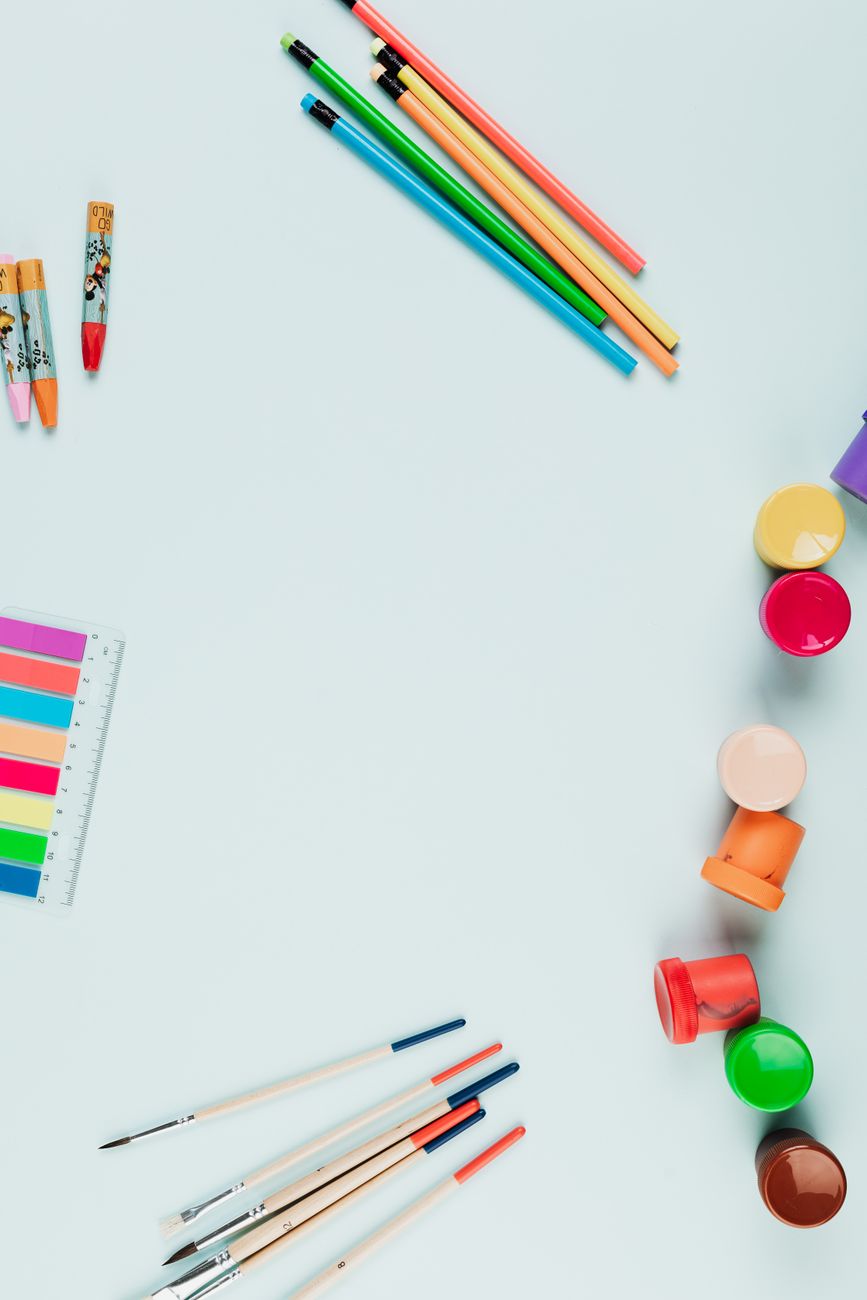 Top view of colorful art supplies arranged on a light background with ample copy space.