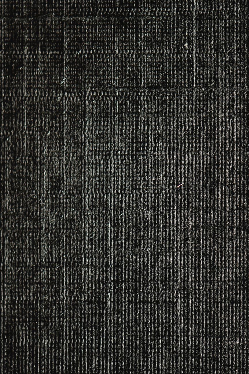 Close-up of dark fabric texture showcasing intricate weave patterns.