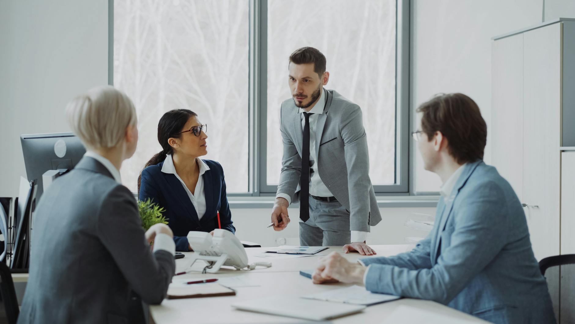 Professionals engaged in a serious business discussion in a bright office environment.
