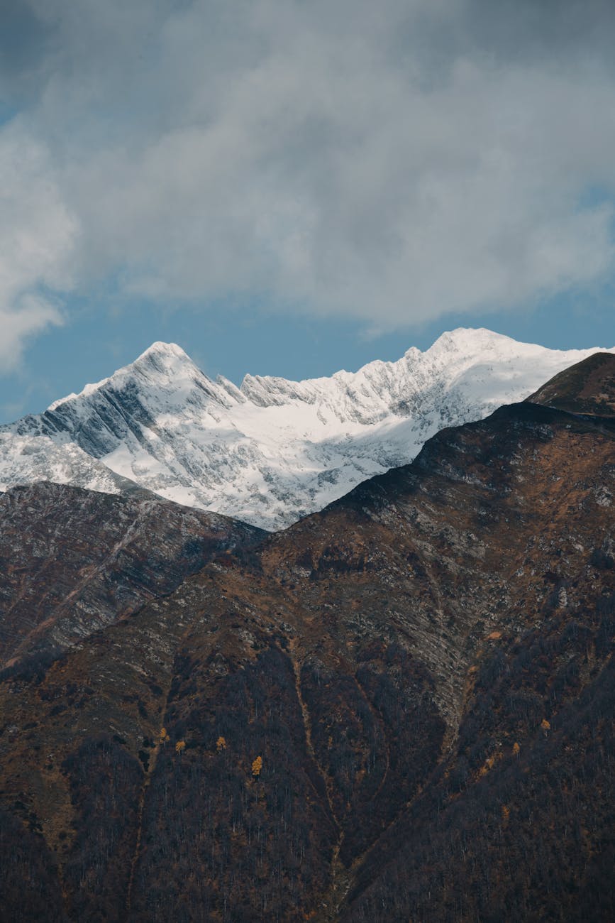 Scenic view of snow-capped mountains under a cloudy sky in Krasnodar, Russia, highlighting nature's beauty.