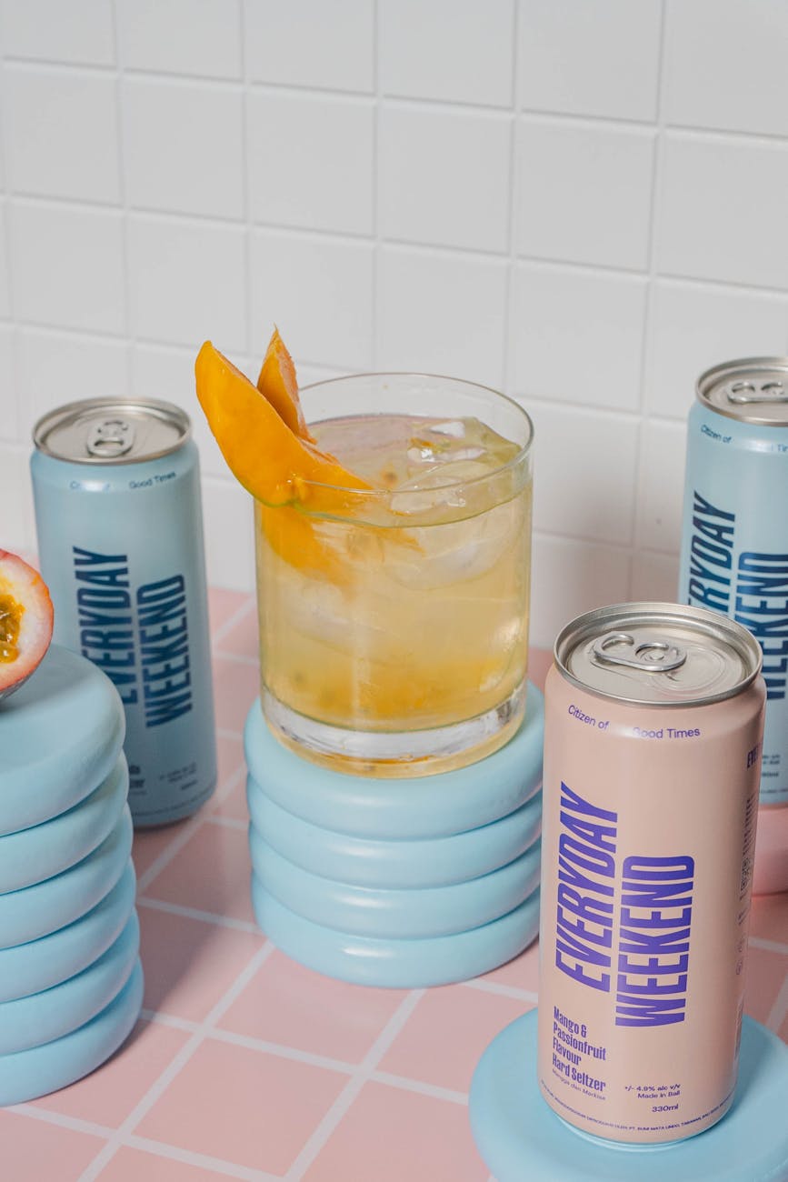 Mixed drink with ice and orange garnish in modern tropical setting, perfect for a refreshing break.