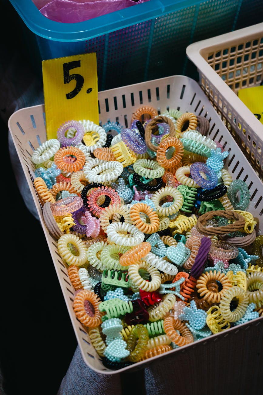 A vibrant assortment of plastic hair ties displayed in a basket marked with a price.