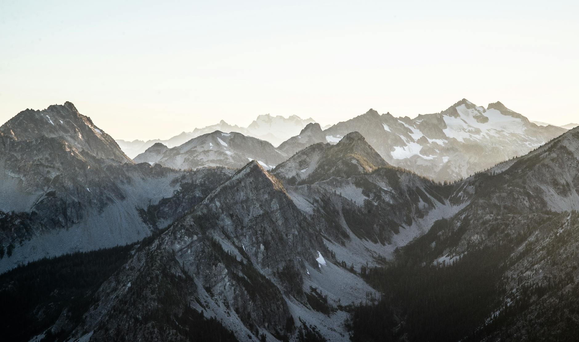 Breathtaking view of snow-covered mountains during dawn, capturing calm nature and winter beauty.