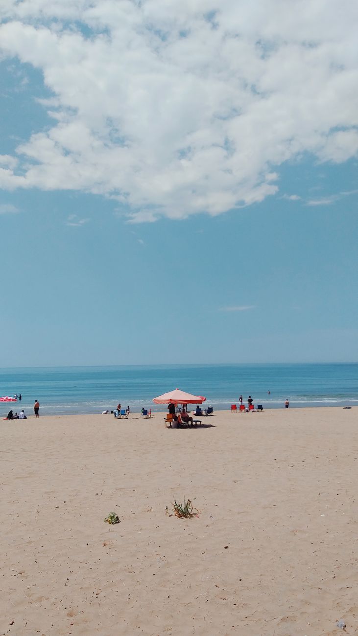 Relaxing scene of Bartın beach with sun umbrellas and people enjoying the summer day.