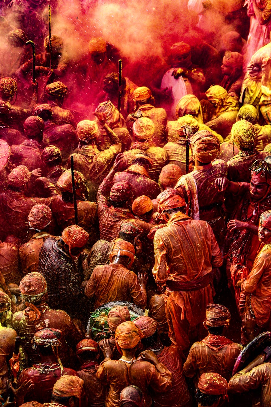 Colorful crowd celebrating Holi with vibrant powders in India.