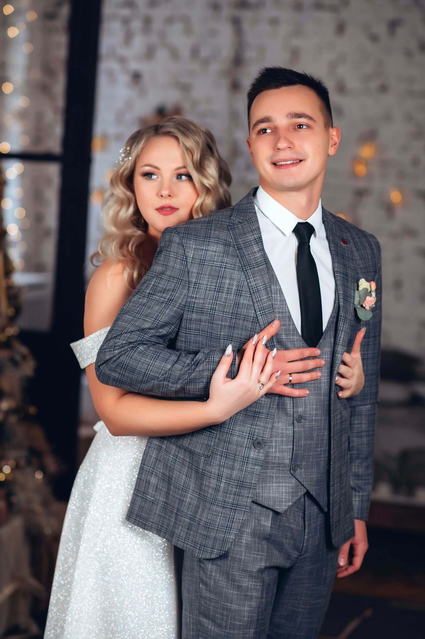 A beautiful bride and groom embracing on their wedding day indoors.