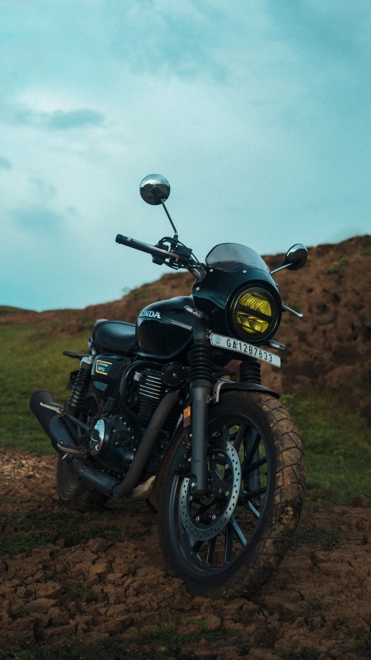 Black motorcycle on a rugged path in rural India, showcasing adventure and exploration.