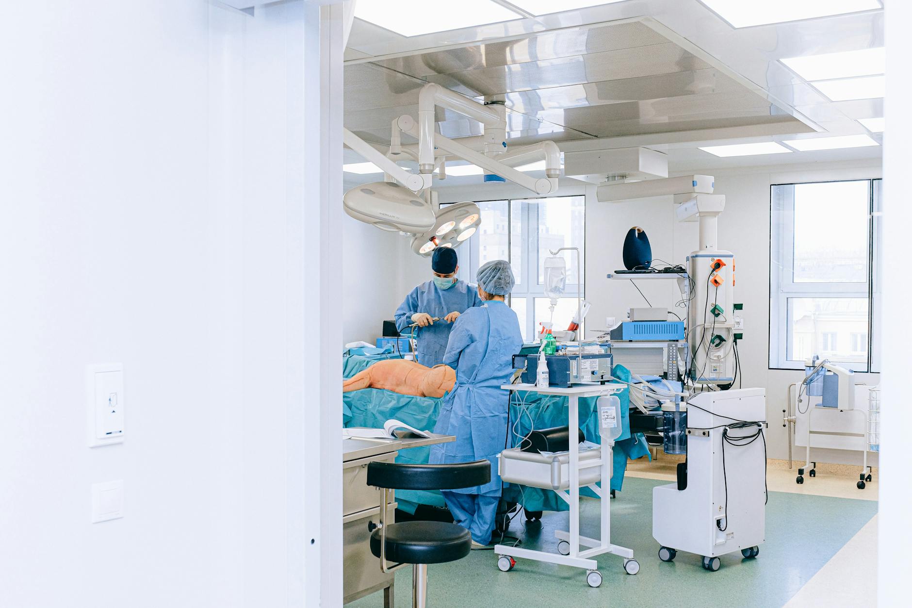 A medical team performs surgery in a well-equipped and sterile operating room.
