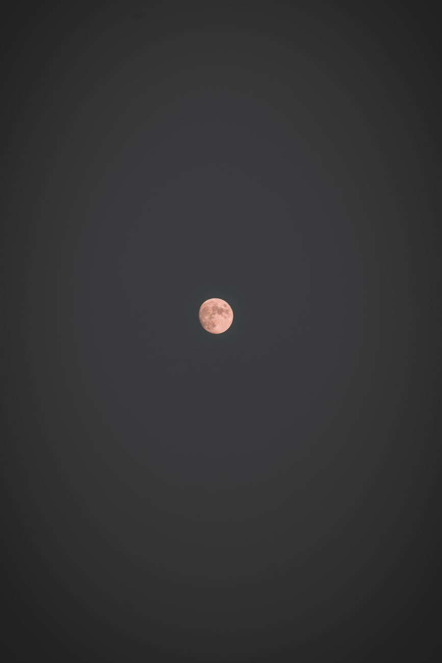 A mesmerizing full moon surrounded by a vast, dark night sky, perfect for mobile wallpaper.