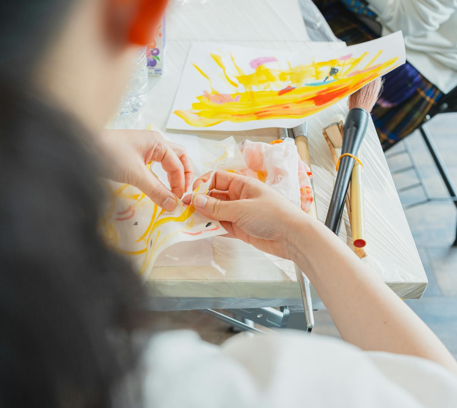 Artist creating vibrant artwork during a class in Shinjuku, Tokyo with painting tools.