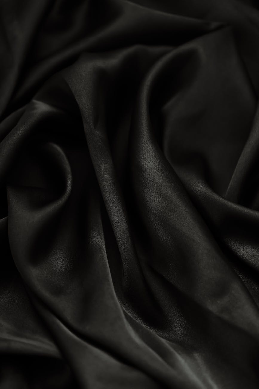 Close-up of smooth rippled black fabric, perfect for backgrounds or textiles.