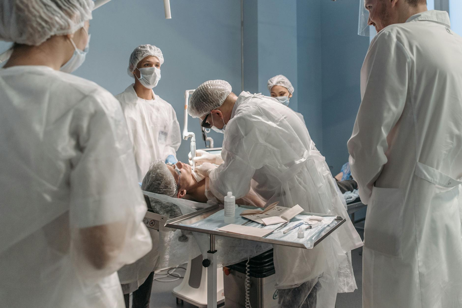Medical professionals performing surgery in a modern operating room, focused on patient care.