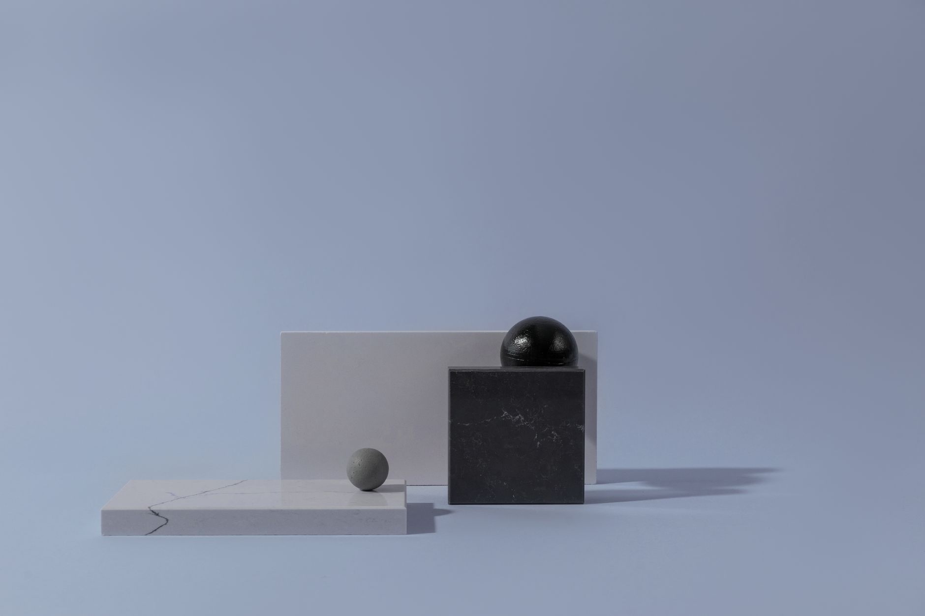 Abstract arrangement of marble surfaces with geometric shapes on a plain background.
