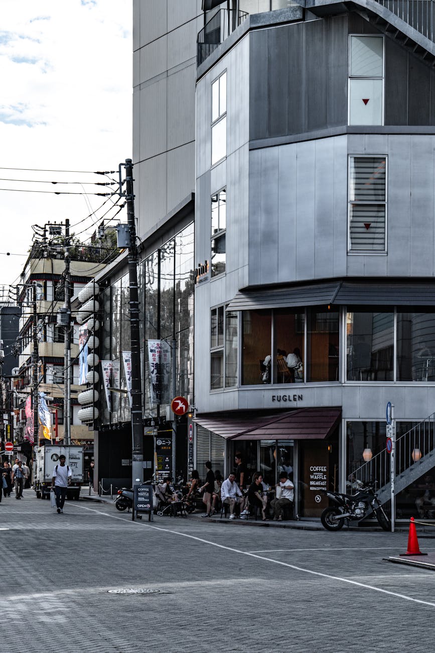 Contemporary urban scene featuring people at a modern building in a bustling city street.
