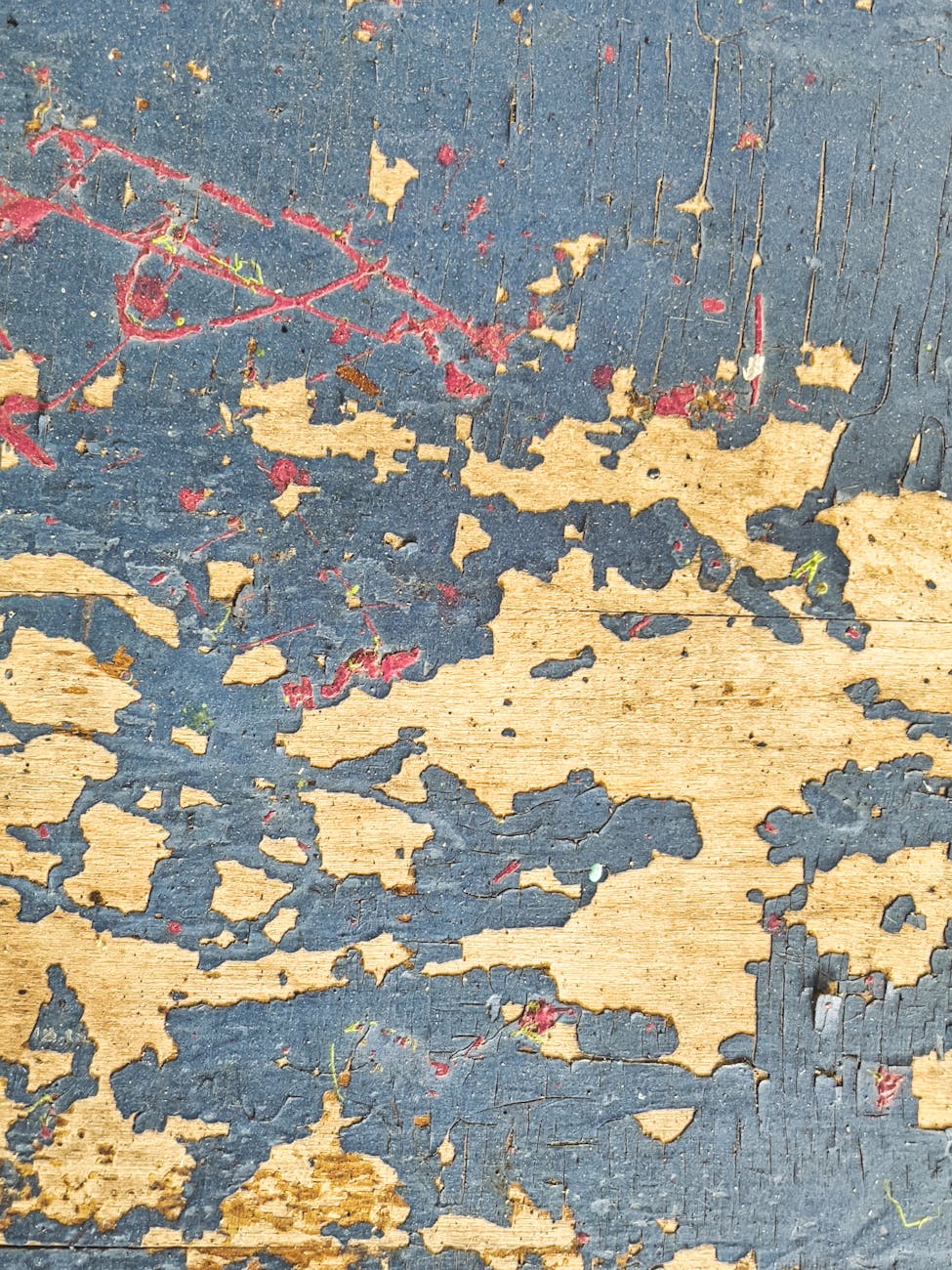 Close-up of weathered, peeling paint on a wooden wall in Slippery Rock, PA, showing decay and texture.