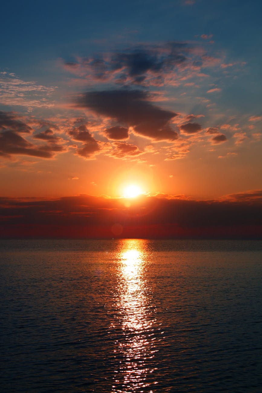 Breathtaking sunset over a calm ocean with vibrant colors and dramatic clouds. Perfect for serene backgrounds.