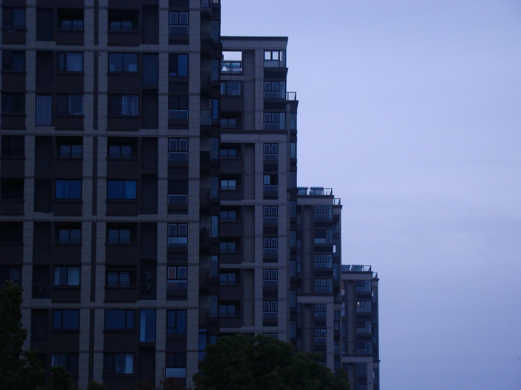 A contemporary skyscraper in a cityscape at dusk showcasing modern architectural design.
