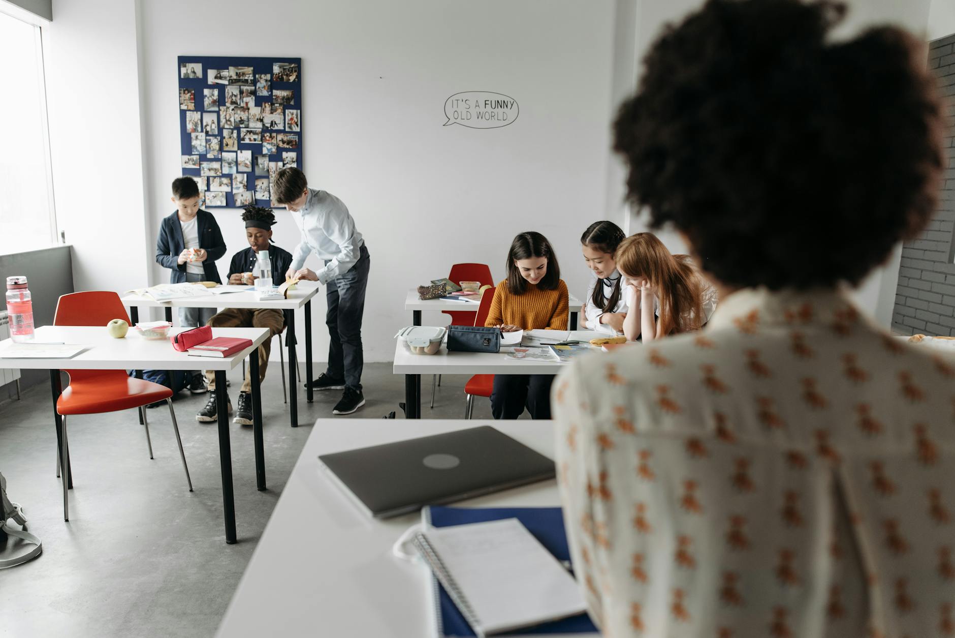 Students focused in a modern classroom with diverse activities and interactions.