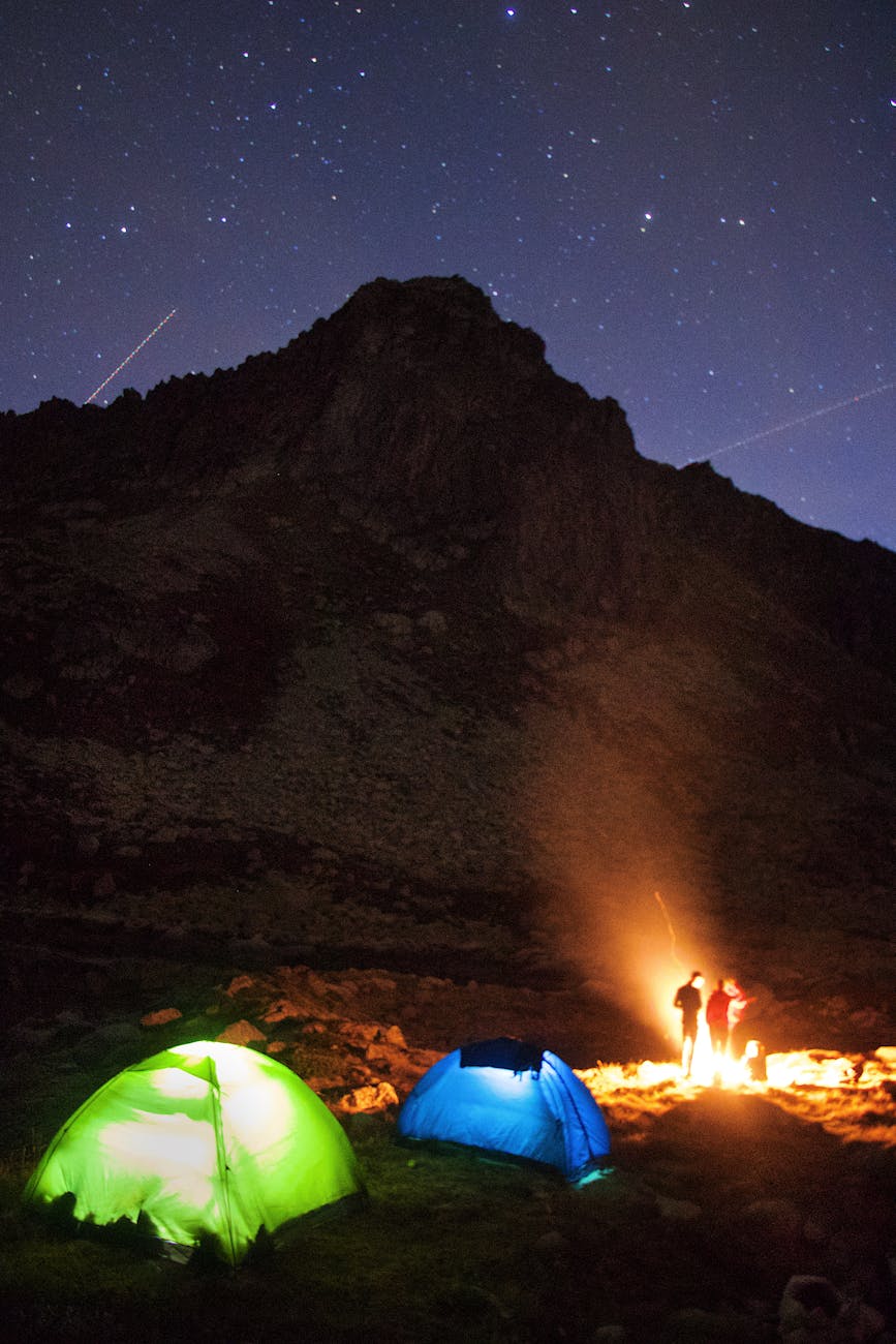Two tents under a starry night sky in Barèges, France, with a campfire.