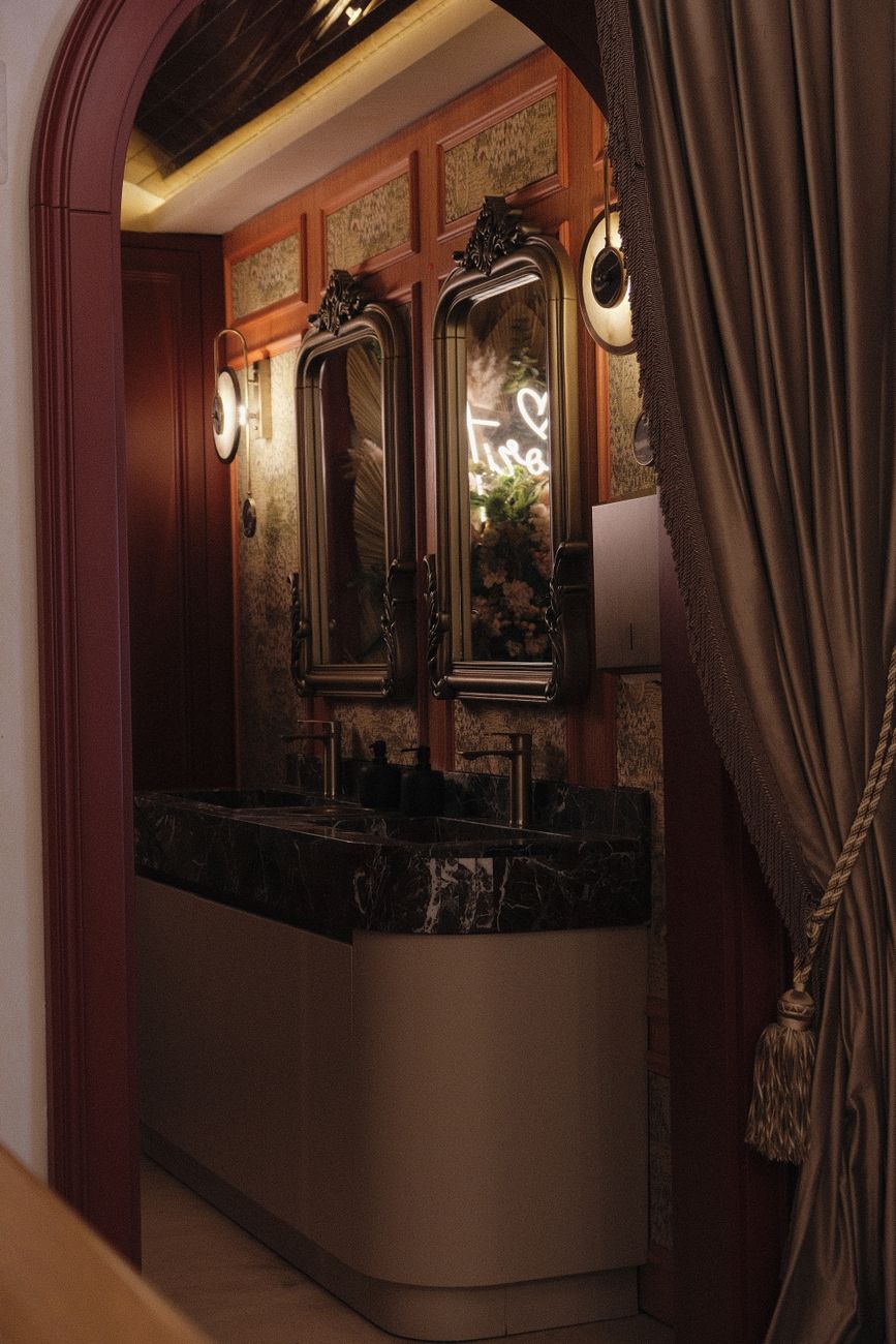 Elegant vintage bathroom interior with ornate mirrors and marble sink.