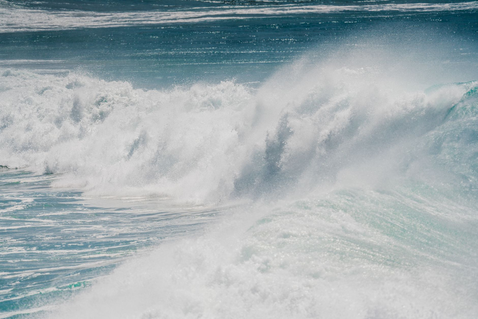 Captivating image of powerful ocean waves crashing under a clear blue sky, showcasing nature's force.