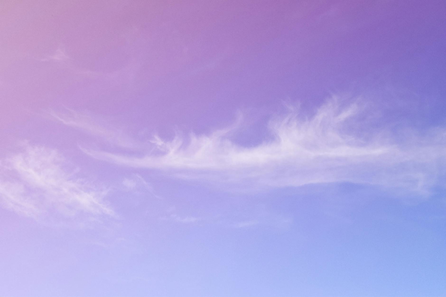 A tranquil purple and blue sky featuring delicate wispy clouds, perfect for backgrounds.