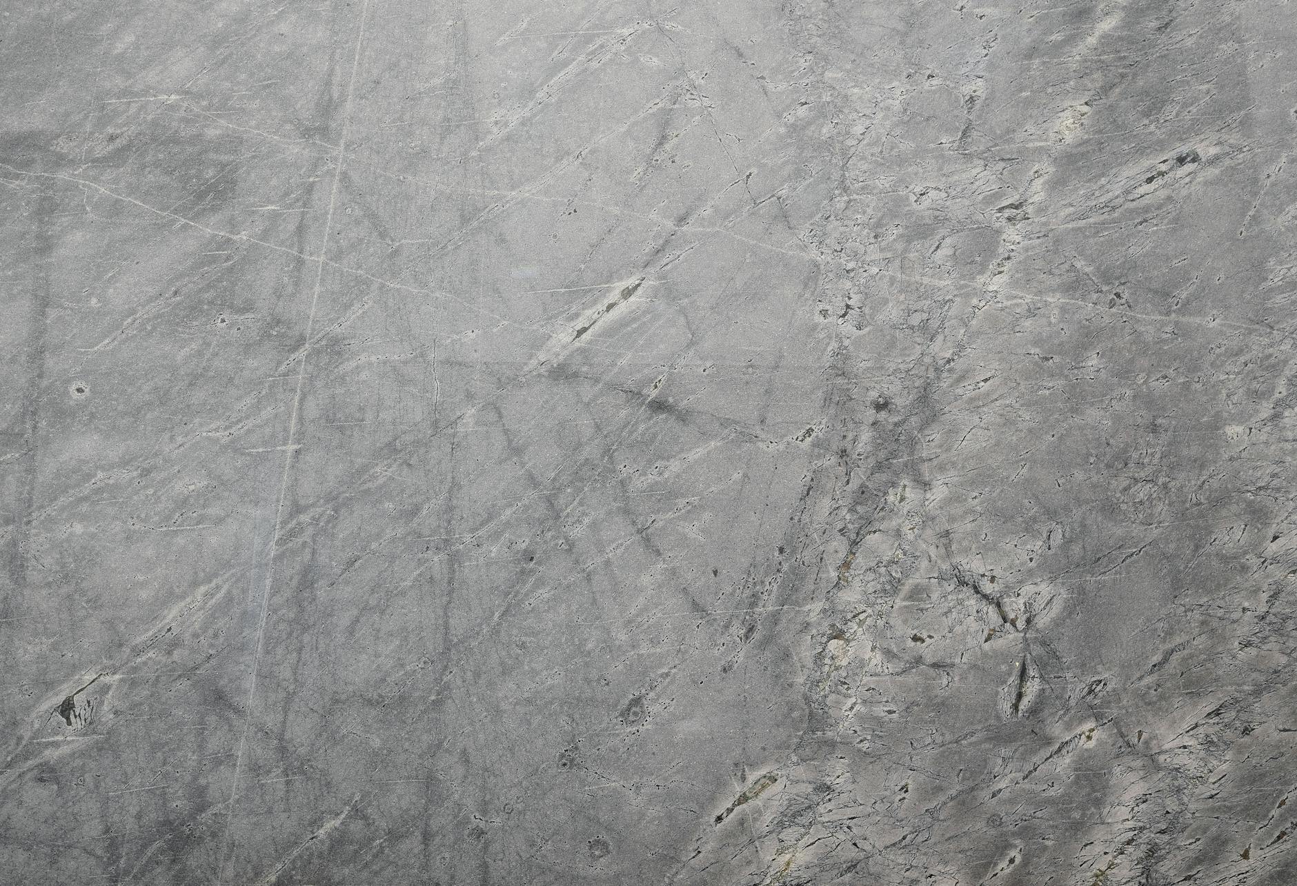 Close-up of a textured grey stone surface suitable for backgrounds or wallpapers.