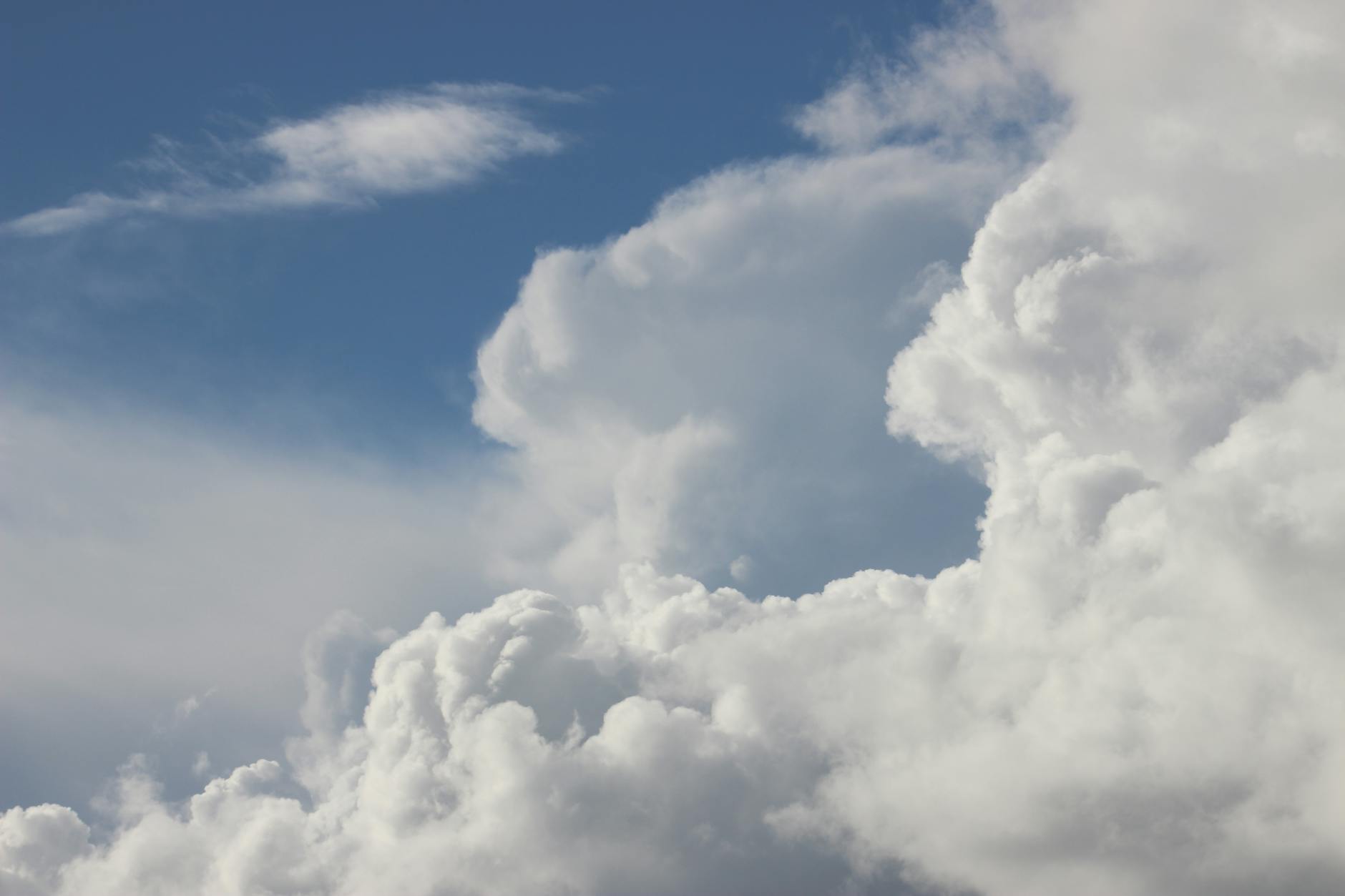Cumulus clouds forming against a bright blue sky, evoking peacefulness and tranquility.