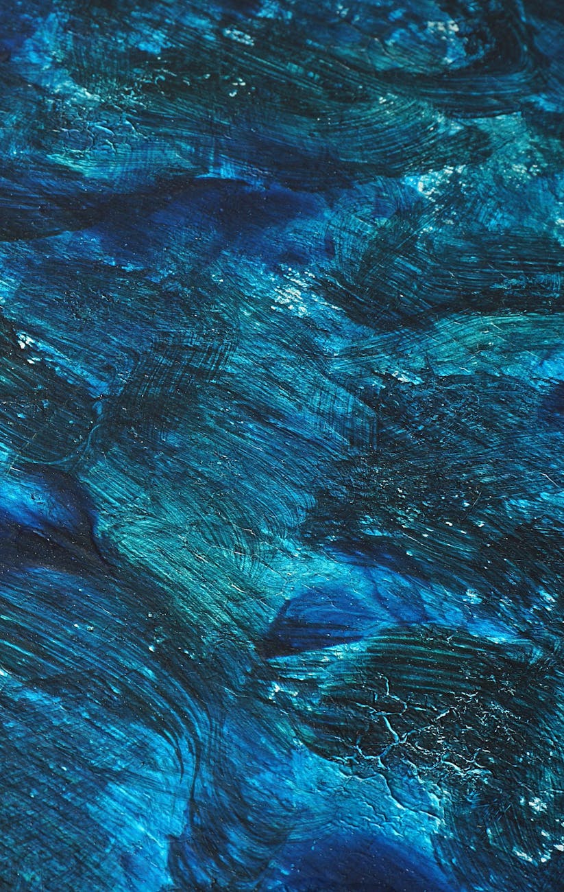 A dynamic abstract painting with rich blue tones and textured brushstrokes evokes movement and depth.