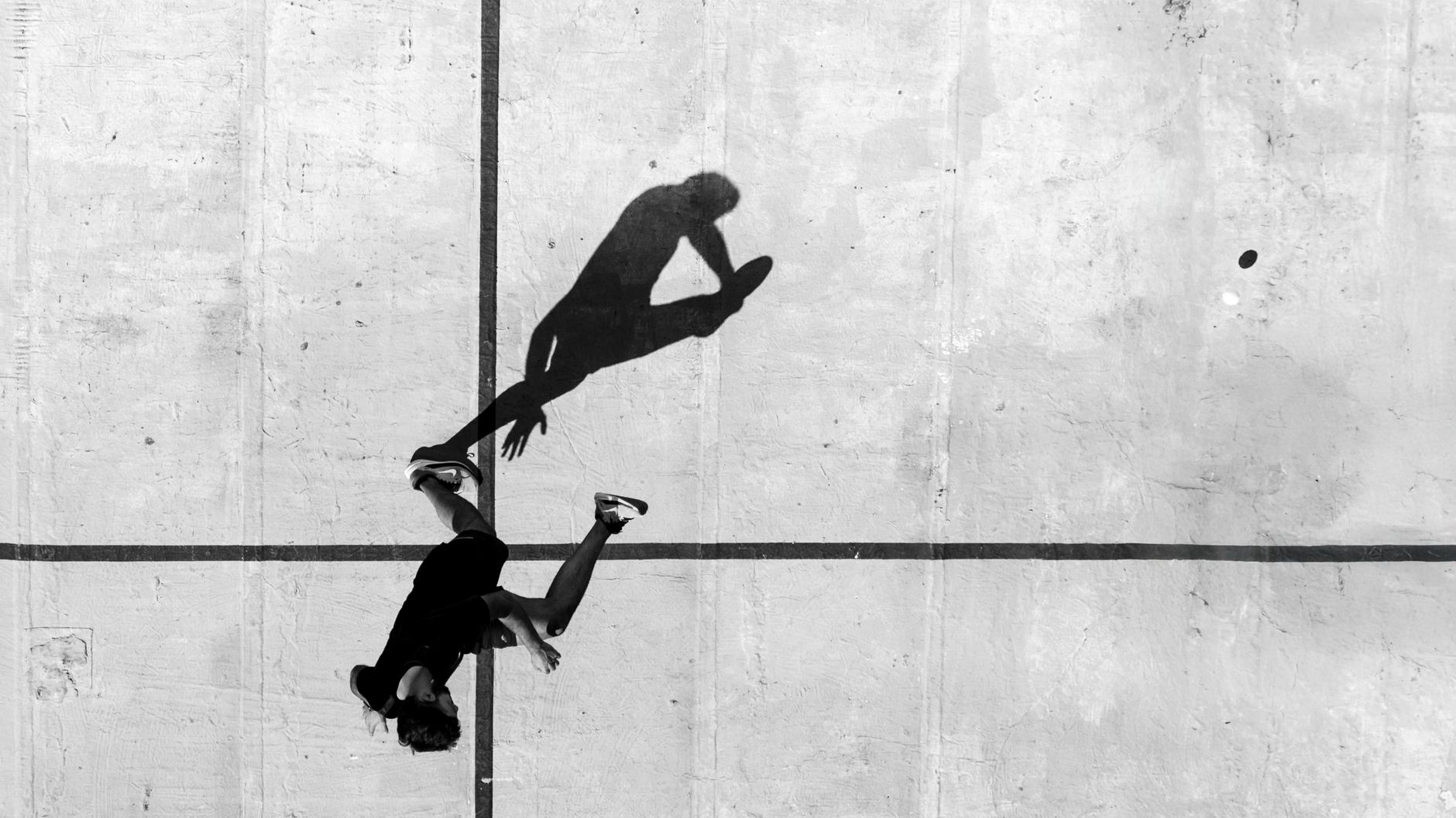 Black and white aerial photo of a person running on concrete in Mar del Plata.
