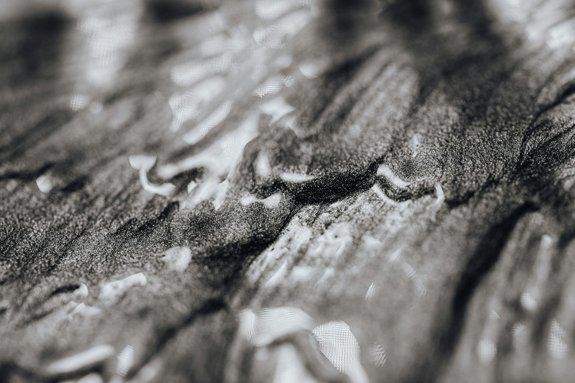 Close-up of abstract black and white textured art with shiny and wet appearance.
